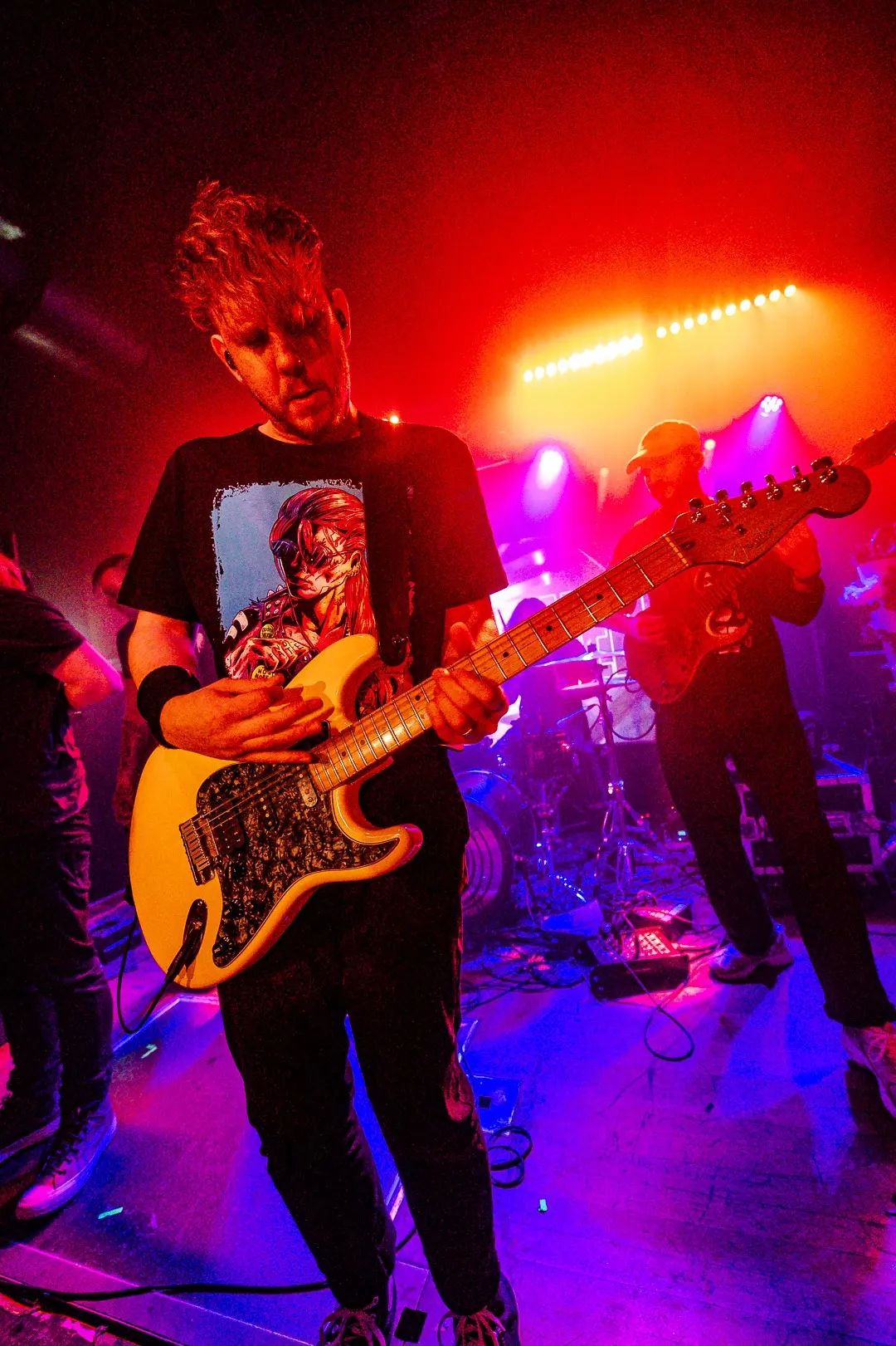 Ed performing under red stage lights